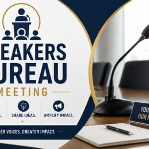 A conference table with a microphone, notepad, and a sign reading "Your Voice, Our Mission" promoting a Speakers Bureau Meeting focused on collaboration, sharing ideas, and amplifying impact.